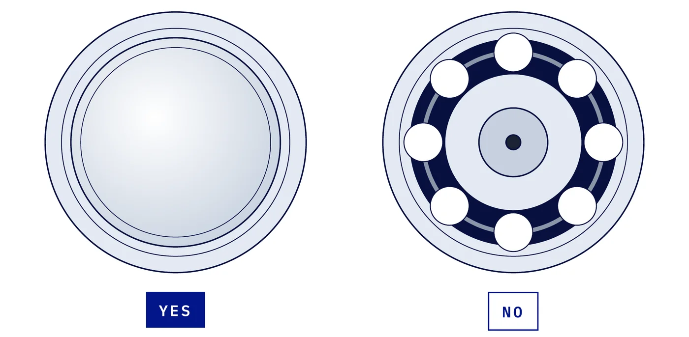 Trolley wheel I-beam side with a welsh plug (a smooth, dished steel cap) next to an open wheel showing the balls
